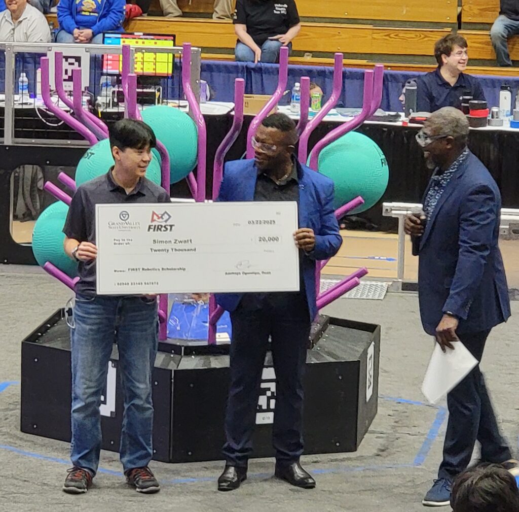Simon zwart Holding a Big Check