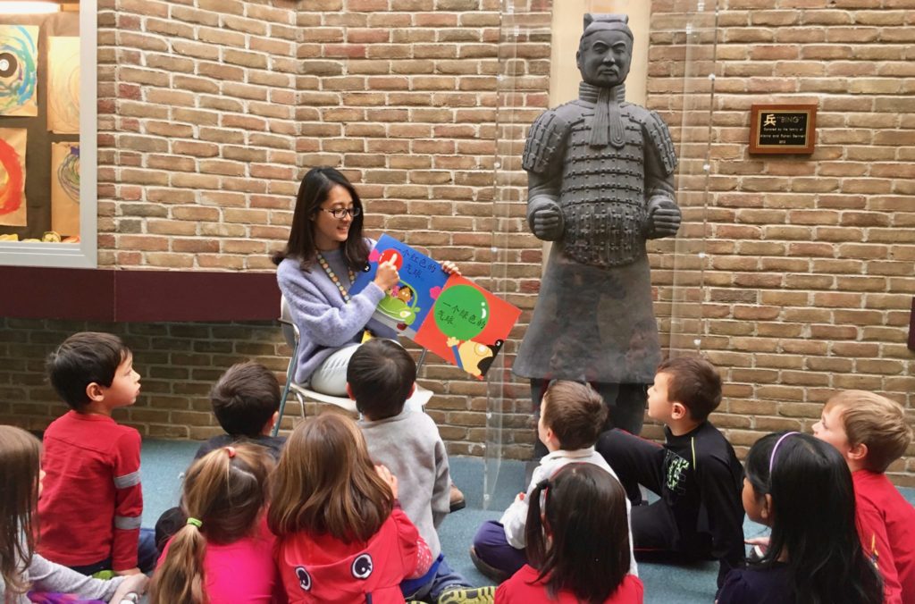 teacher reading a book to students
