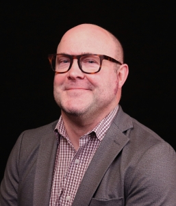 Man with glasses smirking