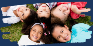 a group of young kids laying in the grass with their faces looking up